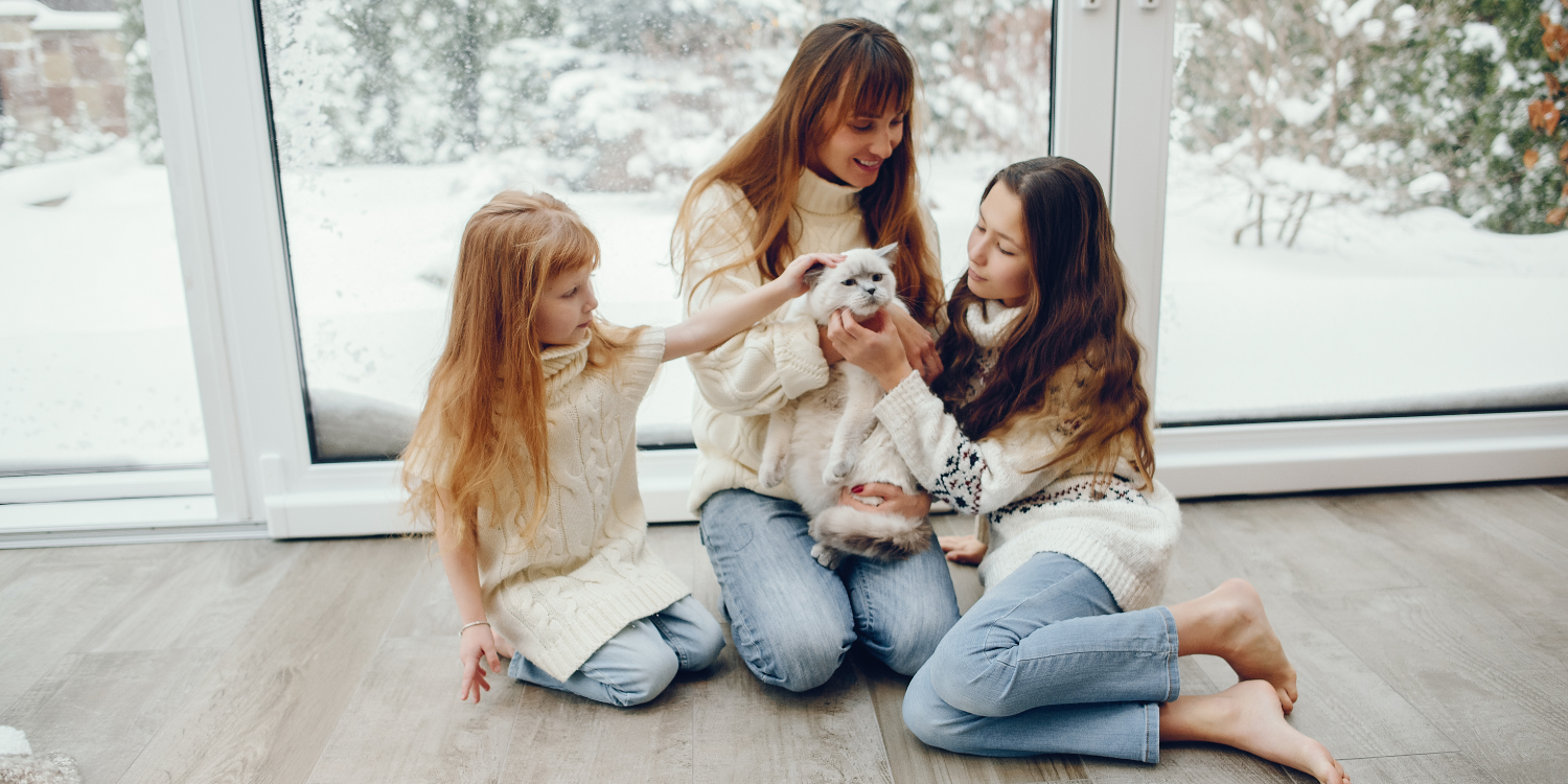 Family playing with cat at home in winter - Product Spotlight: Amana Furnaces