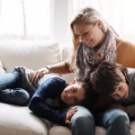 Mom and two boys at home on couch - 3 Eco-Friendly Features of Amana Furnaces: Heat Your Home Sustainably
