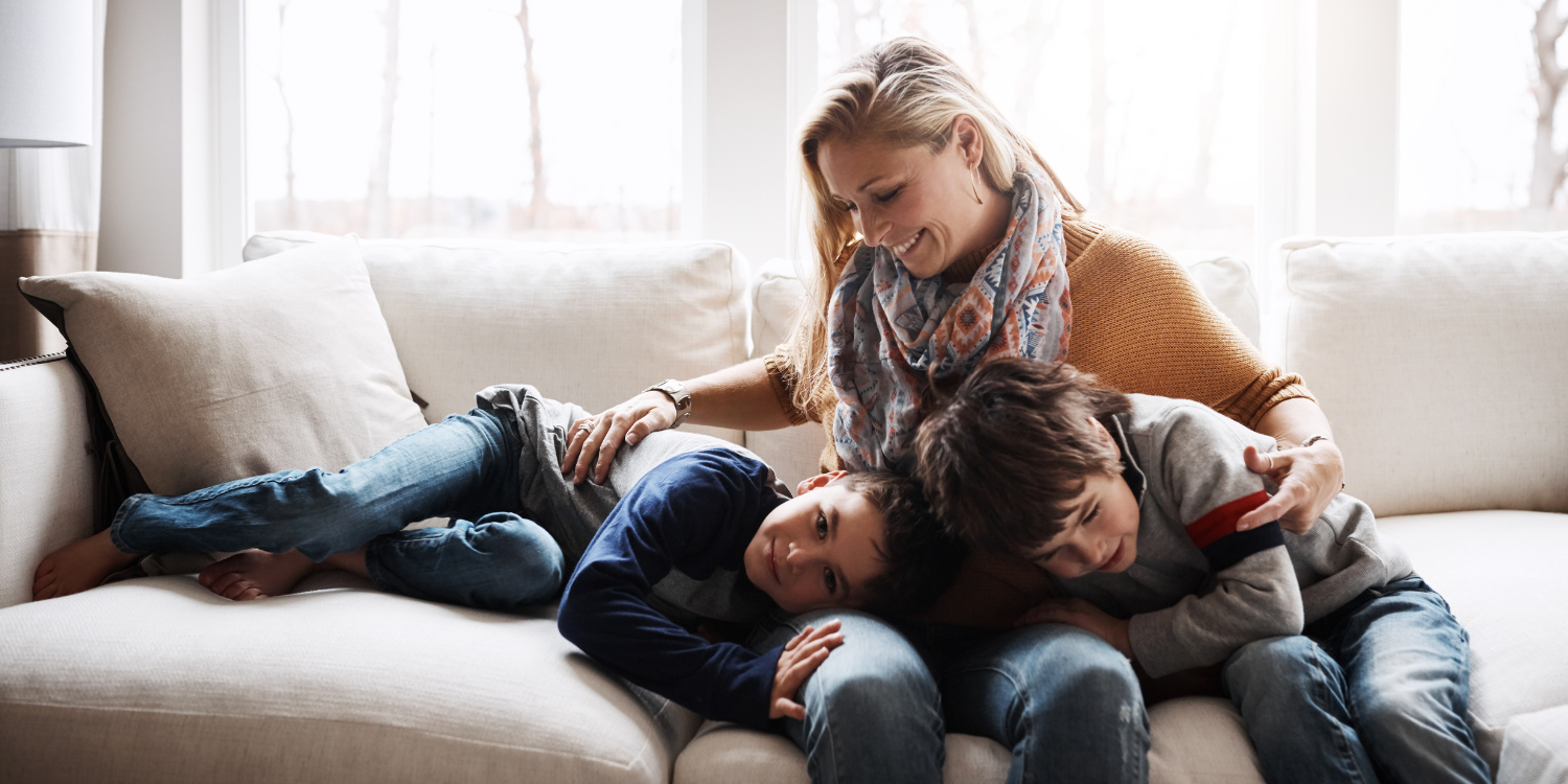 Mom and two boys at home on couch - 3 Eco-Friendly Features of Amana Furnaces: Heat Your Home Sustainably